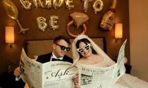 Przywitanie pana młodego w domu młodej. Para w okularach czyta gazetę "The Wedding Post" z nagłówkiem "Miłość".