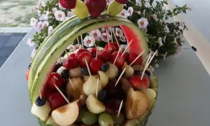 Koszyk z owoców, idealny na wesele, pełen truskawek, winogron i innych pyszności.