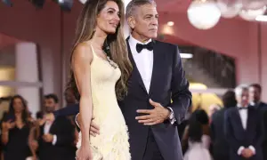 George i Amal Clooney na czerwonym dywanie. Ona w żółtej sukni, on w eleganckim garniturze z muszką, idealnie pasującym do stylu black tie optional.