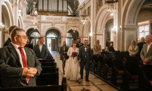 Para młoda idzie do wyjścia z kościoła, a goście śpiewają pieśń na wyjście z kościoła - ślub.