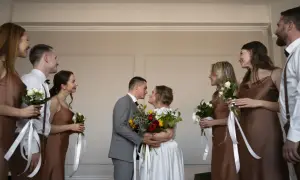 Para młoda w dniu ślubu w piątek, otoczona druhnami i świadkami.