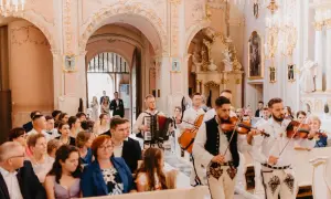 Muzycy grają pieśni na ofiarowanie ślub w kościele. W tle para młoda idzie do ołtarza.