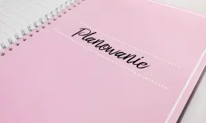 Różowy notatnik z napisem "Planowanie" - idealny do zapisania, kogo zaprosić na wesele i wszystkich innych ważnych szczegółów.