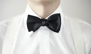 Elegancka biała koszula z czarną muchą i białymi szelkami. Idealny wybór, jaka koszula do muchy na specjalne okazje.