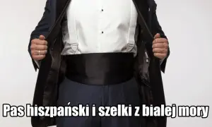Elegancki mężczyzna w czarnym smokingu, białej koszuli i szelkach. Na brzuchu widoczny czarny pas do smokingu.