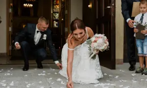 Panna młoda i pan młody zbierają monety rozsypane przed kościołem. To piękna pieśń na wejście do kościoła ślub.