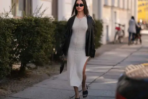Elegancka sukienka dresowa w beżowym kolorze, zestawiona z czarną ramoneską i okularami. Stylowe sukienki dresowe na co dzień i wieczór.