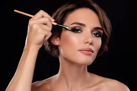 Brunetka zmysłowo podkreśla oczy zielonym cieniem, tworząc idealny makijaż ślubny.