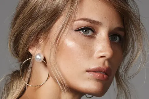 Delikatny makijaż na wesele dla blondynek: subtelne podkreślenie oczu i ust, złote kolczyki.