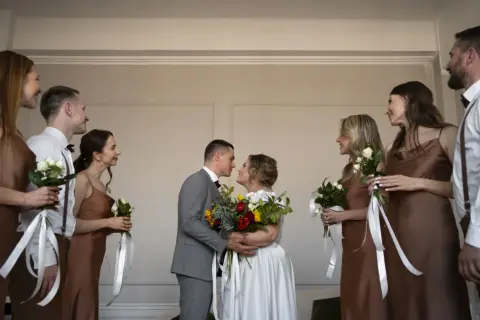 Para młoda w dniu ślubu w piątek, otoczona druhnami i świadkami.