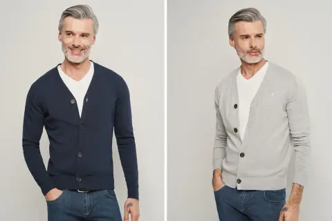 Elegancki mężczyzna pokazuje, jak nosić sweter męski. Granatowy i szary kardigan z dekoltem V, biały T-shirt i jeansy.