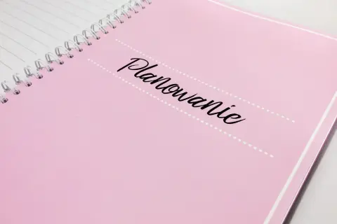 Różowy notatnik z napisem "Planowanie" - idealny do zapisania, kogo zaprosić na wesele i wszystkich innych ważnych szczegółów.