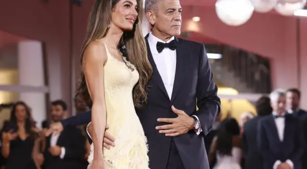 George i Amal Clooney na czerwonym dywanie. Ona w żółtej sukni, on w eleganckim garniturze z muszką, idealnie pasującym do stylu black tie optional.