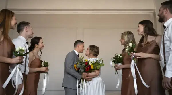 Para młoda w dniu ślubu w piątek, otoczona druhnami i świadkami.