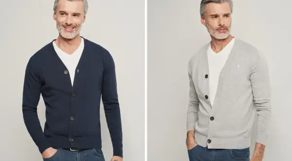 Elegancki mężczyzna pokazuje, jak nosić sweter męski. Granatowy i szary kardigan z dekoltem V, biały T-shirt i jeansy.