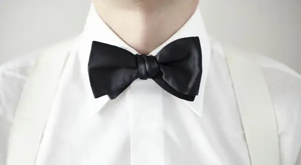 Elegancka biała koszula z czarną muchą i białymi szelkami. Idealny wybór, jaka koszula do muchy na specjalne okazje.