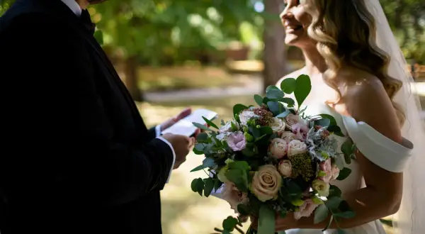 Para młoda podczas romantycznej przysięgi małżeńskiej. Ona trzyma bukiet, on czyta z kartki.