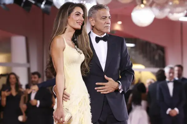 George i Amal Clooney na czerwonym dywanie. Ona w żółtej sukni, on w eleganckim garniturze z muszką, idealnie pasującym do stylu black tie optional.