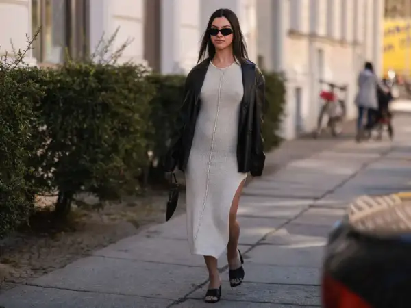Elegancka sukienka dresowa w beżowym kolorze, zestawiona z czarną ramoneską i okularami. Stylowe sukienki dresowe na co dzień i wieczór.