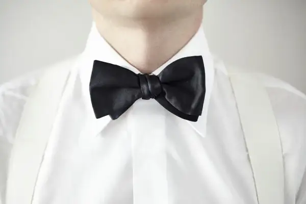 Elegancka biała koszula z czarną muchą i białymi szelkami. Idealny wybór, jaka koszula do muchy na specjalne okazje.